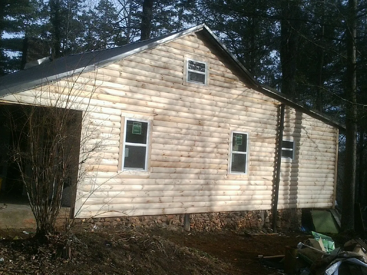 New log siding and dark metal roofing on a gable end in Miami
