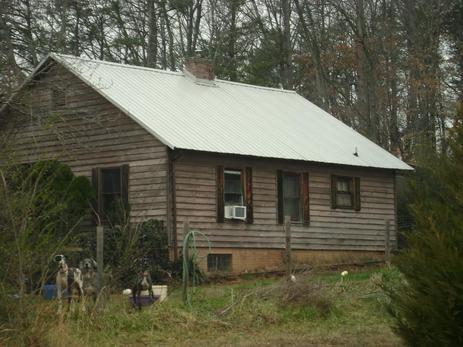 White metal roof on an old wood sided farmhouse, from a Asphalt Shingle Roof Repair job in Miami